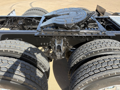 Kenworth T880 chassis showing fifth wheel, dual rear axles, classic drivetrain area with tires and frame.