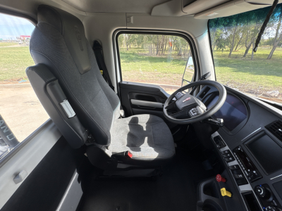 Kenworth T880 cab interior showing steering wheel and driver seat with dashboard controls.