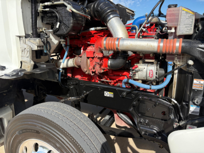 Kenworth T880 engine bay with red engine block, blue hoses, and silver air intake tube visible.