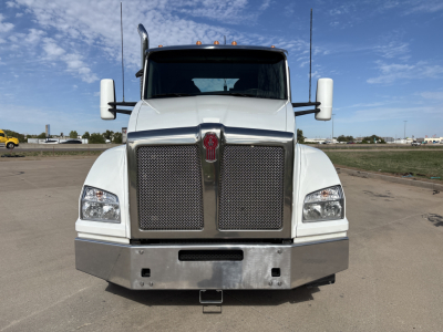 Kenworth T880 front view showing large chrome grille, dual rectangular headlights, white cab, and metallic bumper.