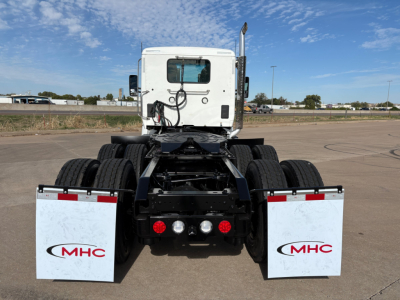 Kenworth T880 rear view showing chassis, dual rear axles, mud flaps with MHC logo, and fuel lines.
