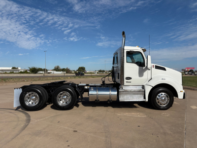 Kenworth T880 cab and chassis side profile showing white tractor with chrome fuel tanks and three rear axles. No visible text on the truck.