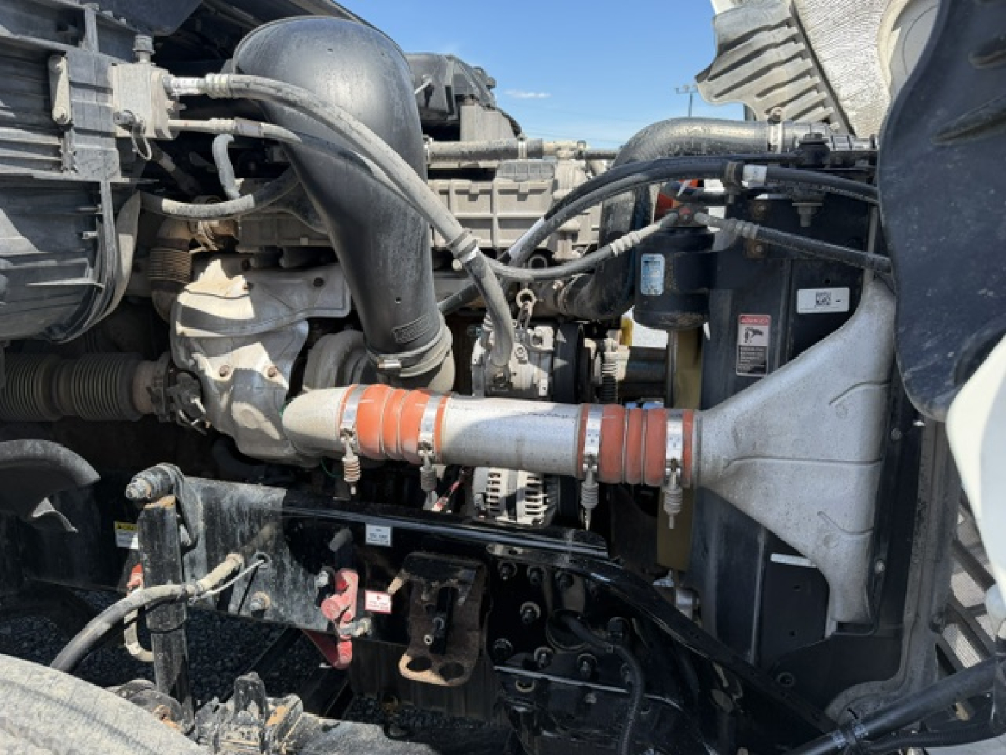 Freightliner Cascadia engine bay showing intake hoses and cooling system components.