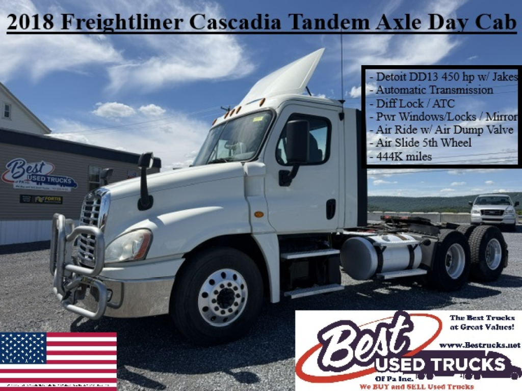 Truck cab in view showing 2018 Freightliner Cascadia Tandem Axle Day Cab with chrome bumper guard and side text panel listing features.