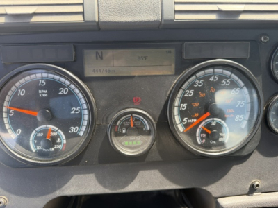 Panel view of a Freightliner Cascadia dashboard showing rpm gauge, speedometer, fuel/temp indicators, and central digital display with N and 85°F; VIN 3AKJGEDV7JSJJ2844 not visible clearly