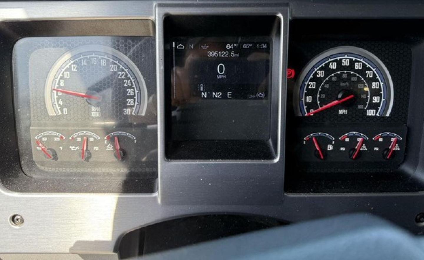 Dash of a 2020 Mack Anthem truck showing gauges and center touchscreen display with warning lights