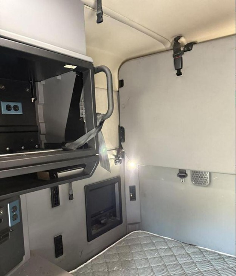 Cab interior of a 2020 Mack Anthem sleeper cab showing upper bunk area, control panels, and mounts inside the truck cabin.