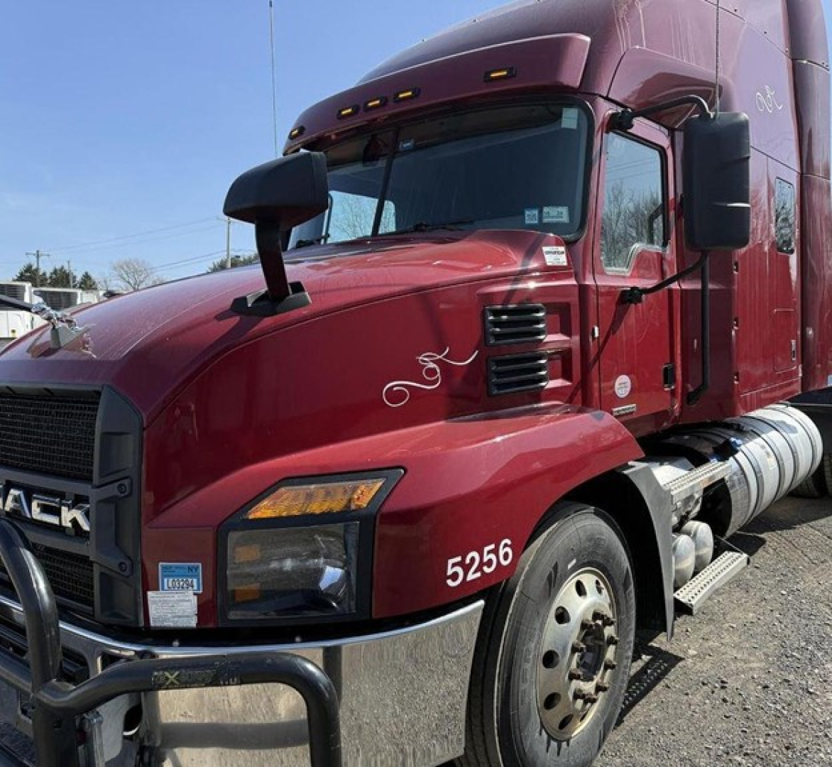 Truck hood and front quarter of a red 2020 Mack Anthem sleeper cab truck showing number 5256 and side steps.