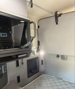 Cab interior of a 2020 Mack Anthem sleeper cab showing upper bunk area, control panels, and mounts inside the truck cabin.