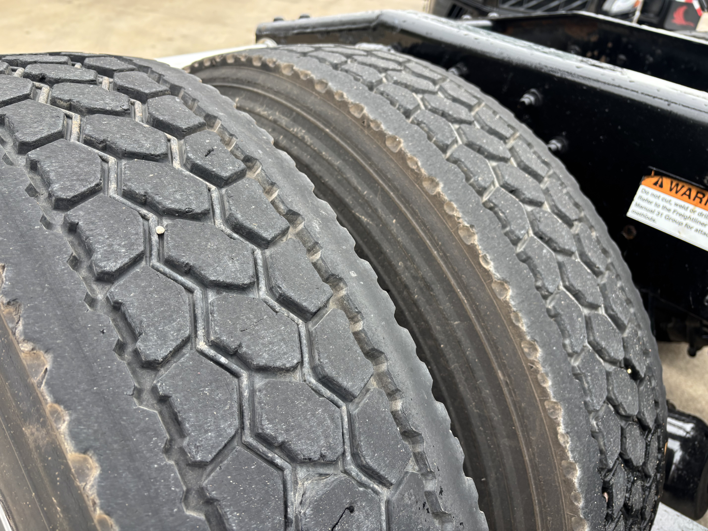 Tandem rear dual tires on Freightliner Cascadia 126 tractor showing tread pattern and dual wheel setup.