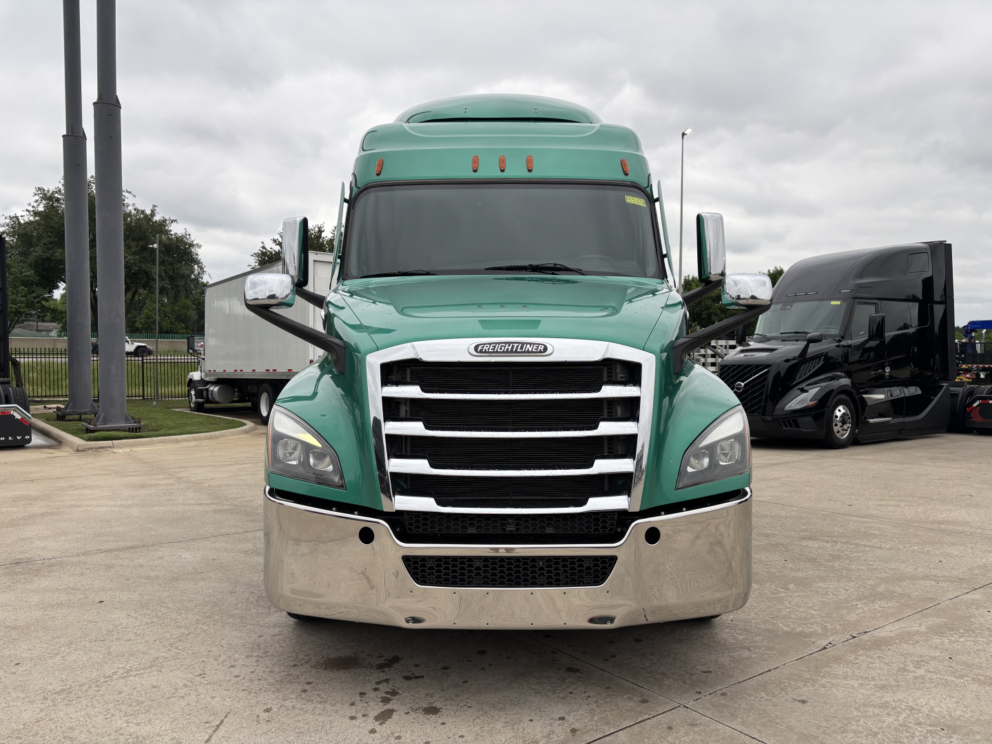 Freightliner Cascadia 126 front view showing chrome grille with stacked bars and green cab