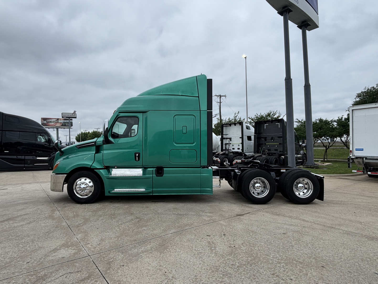 Green Freightliner Cascadia 126 tractor facing left, side view with sleeper cab, chrome steps, dual rear axles, no trailer attached.