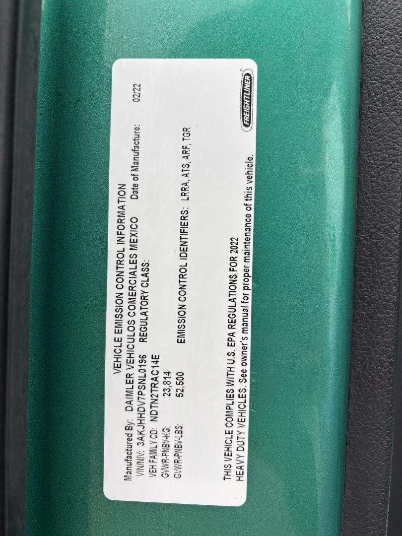 Label on Freightliner truck showing emission control information and model details.