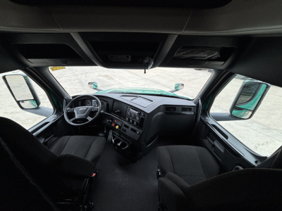 Freightliner Cascadia 126 cab interior showing steering wheel, dashboard, and twin front seats.