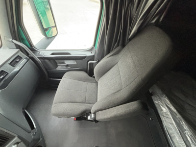 Seat and cab interior of a Freightliner Cascadia 126 truck showing front seat and doorway area.