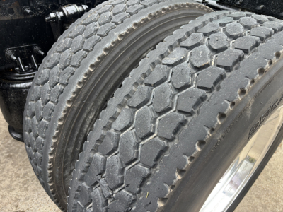 Front dual rear tires on a Freightliner Cascadia 126 tractor showing tread pattern and tire sidewall with wheel hub