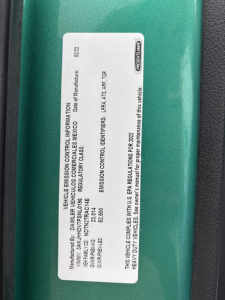Label on Freightliner truck showing emission control information and model details.