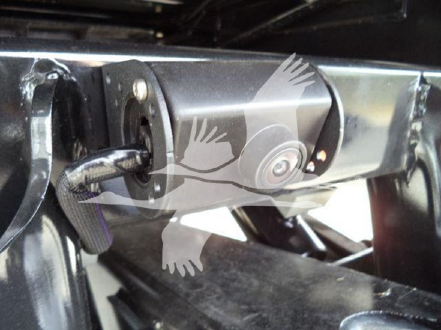 View of front hitch area on a 2024 Ford F550 rollback truck showing mounting hardware and connector.