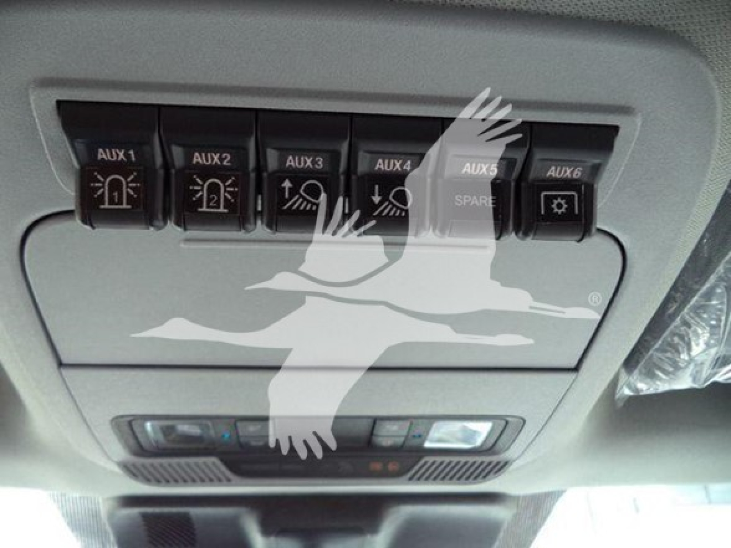Ford F550 dash panel showing Aux switches labeled AUX 1 to AUX 6, plus SPARE and a control module; overhead console and cabin lighting in view.