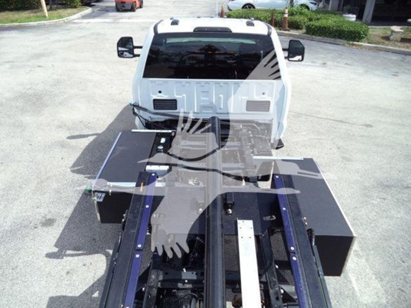 Ford F-550 rollback truck front view with flatbed equipment and hydraulic chassis in foreground.
