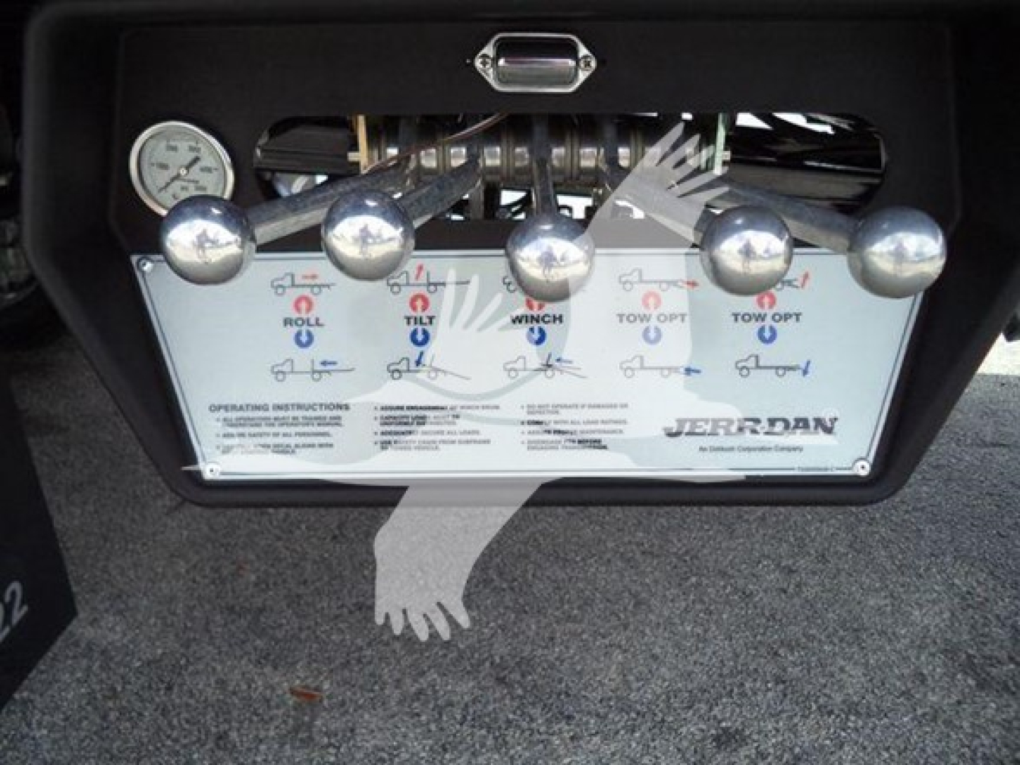 Winch control panel on a Ford F550 rollback showing five large chrome levers labeled Roll, Tilt, Winch, Tow, and Off with push buttons and a Jerr-Dan logo.