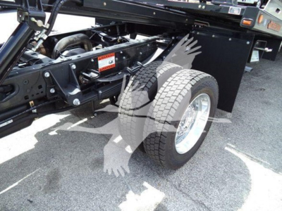 Truck chassis and dual rear wheels showing roll-back tow truck setup with black frame and components.