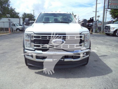 Front view of a white 2024 Ford F-550 rollback truck with Ford emblem grille and chrome bumper; visible text includes Ford emblem on grille, license-like front area.