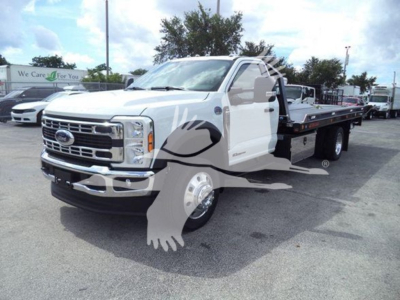 Ford F-550 rollback tow truck in white with flatbed, front grille and headlights visible.