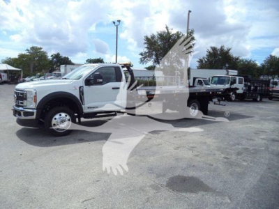 Ford F-550 rollback tow truck front left view with crane setup in lot; visible text shows Ford chassis and wheels; no legible model stickers or gauges readable