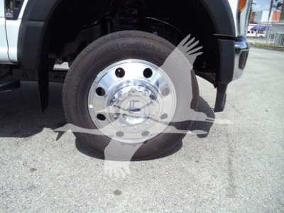 Ford F-550 wheel and tire visible on a rollback truck front corner, with chrome hubcap and tire brand readable on sidewall.