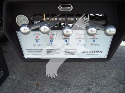 Winch control panel on a Ford F550 rollback showing five large chrome levers labeled Roll, Tilt, Winch, Tow, and Off with push buttons and a Jerr-Dan logo.