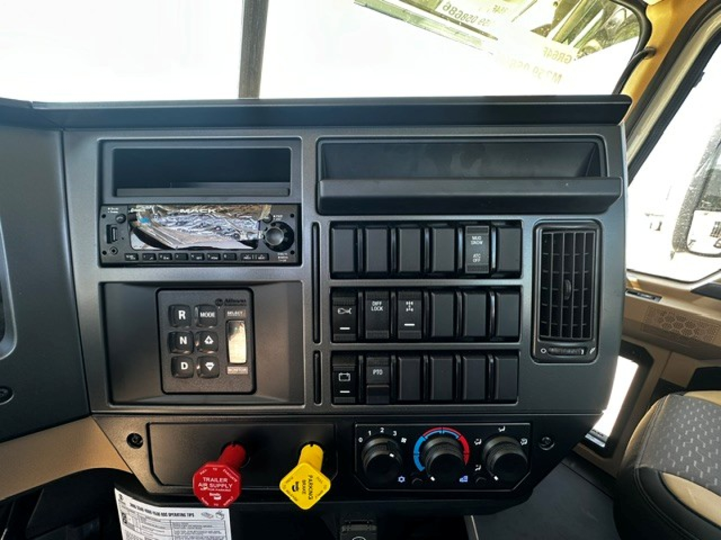 Dashboard panel of a 2027 Mack GR64F cab and chassis showing radio, control switches, and climate controls.