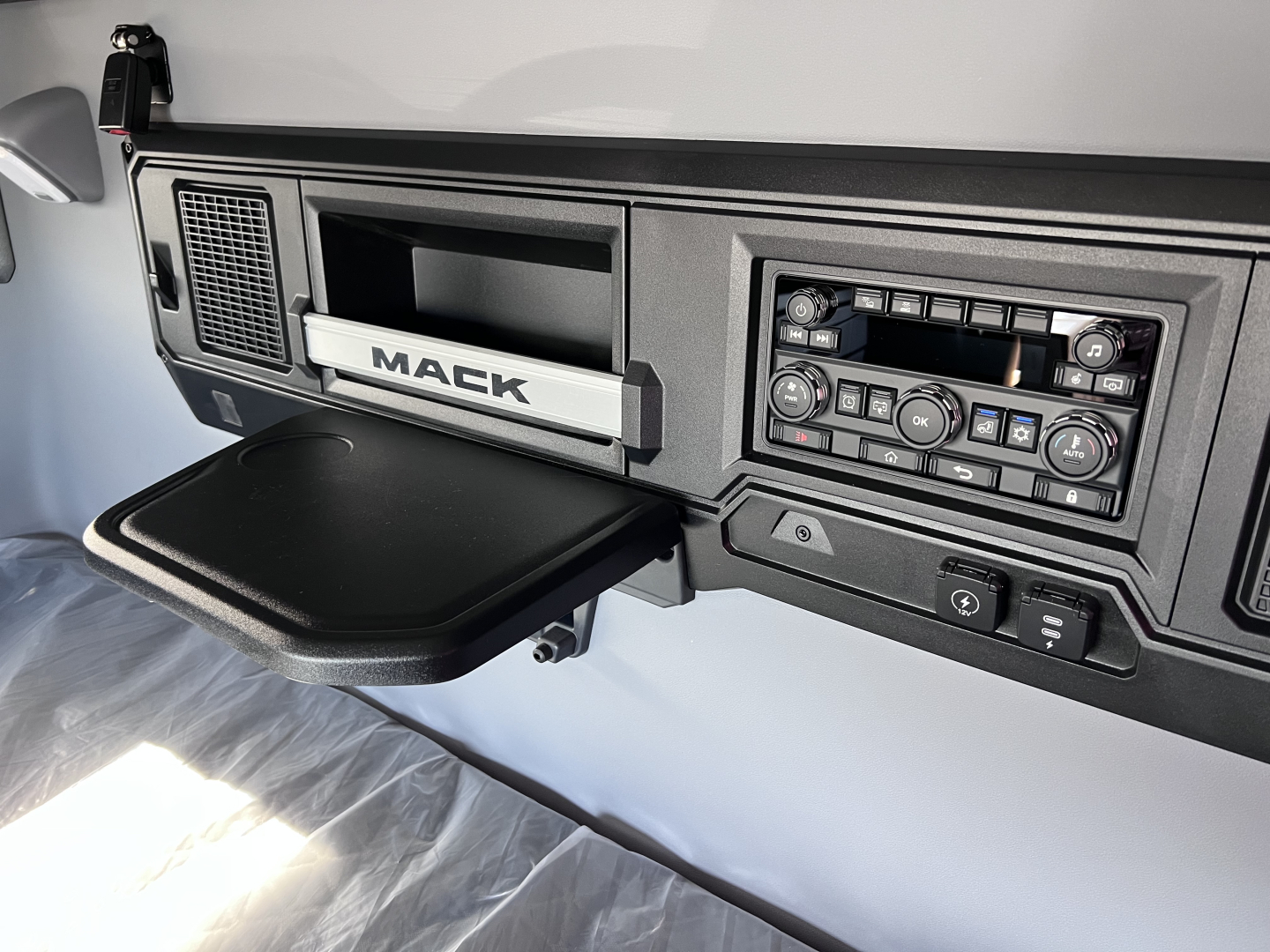 Mack PR64T76H truck interior dashboard showing infotainment, control panel, and cup holder area.