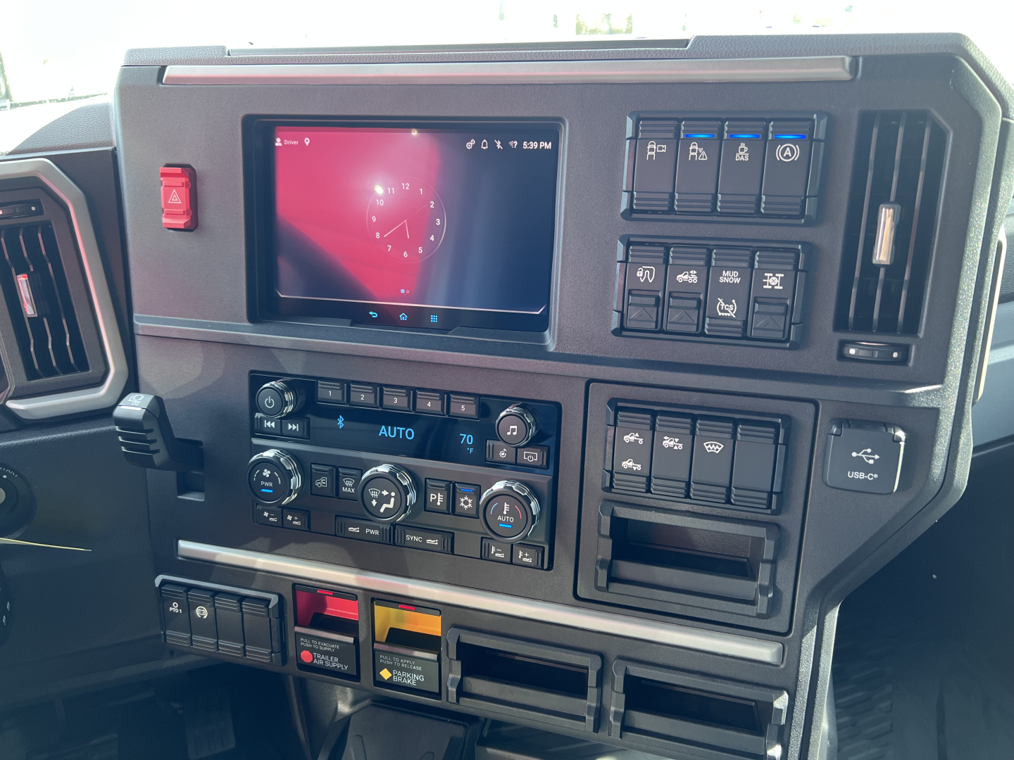 Dashboard of 2026 Mack PR64T76H showing touchscreen display and control panel with climate, media, and rectangular switches.