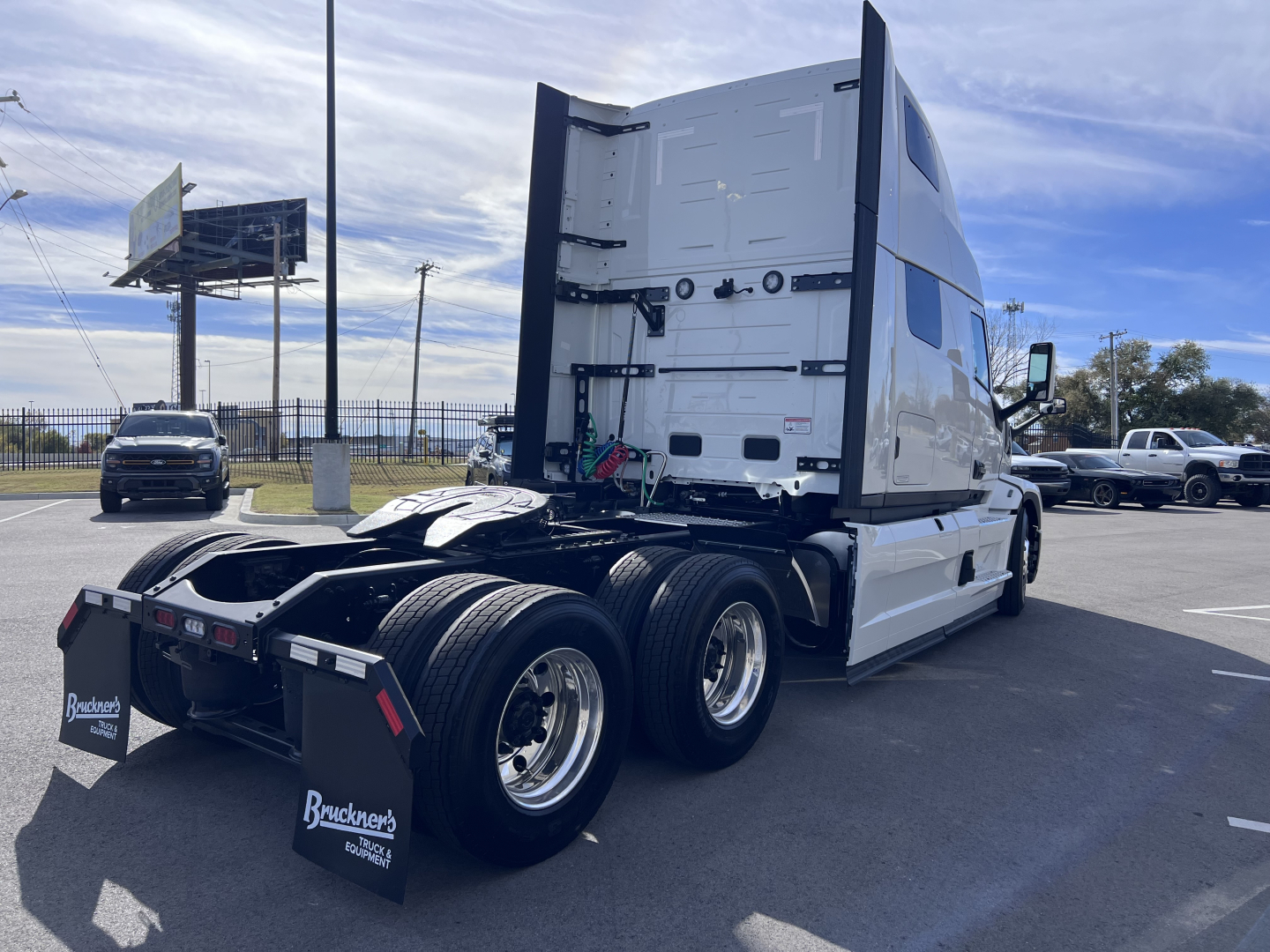 Mack PR64T76H highway tractor rear view showing dual rear axles and fifth wheel plate with various hoses and connectors.