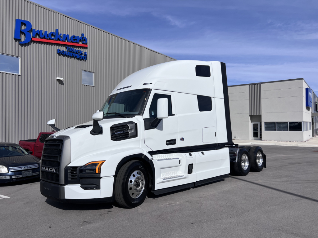 Mack PR64T76H tractor-trailer truck parked outside a dealership.