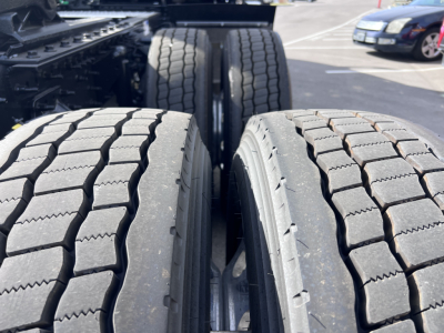 Truck axle setup showing dual rear tires and tread pattern on outer tires in the drive axle area.