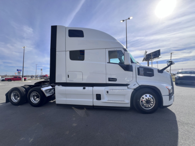 Side view of a white Mack PR64T76H semi-truck tractor in a parking lot. Visible text on side panel includes no explicit labels; no legible stickers or warnings readable in this image.