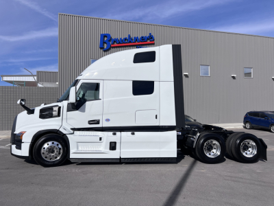 Semi truck tractor in white with raised sleeper cab side view showing Mack PR64T76H spec details on the cab and chassis.