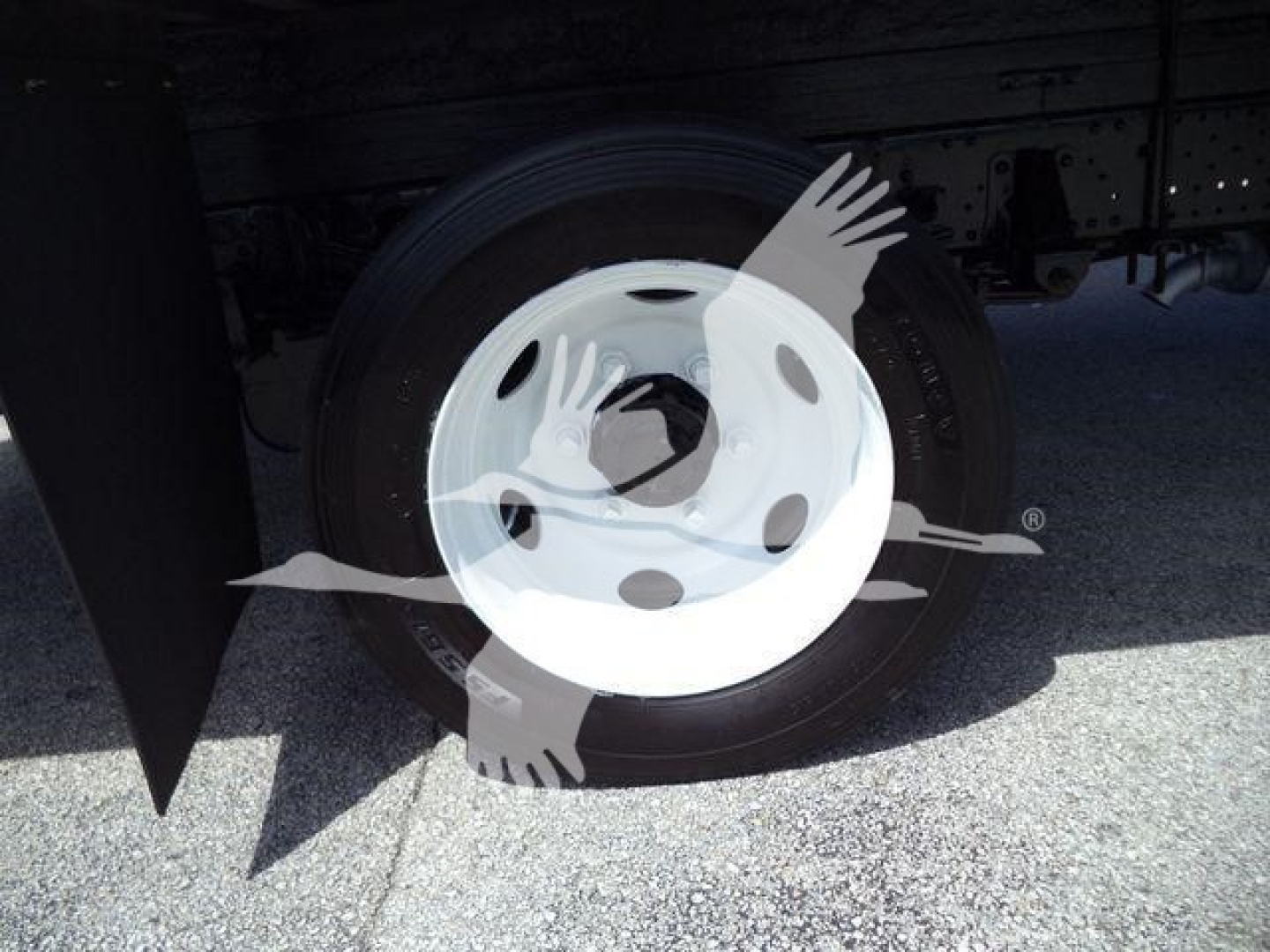 Truck wheel and tire under body of 2020 Isuzu NPR HD showing steel hub with tire