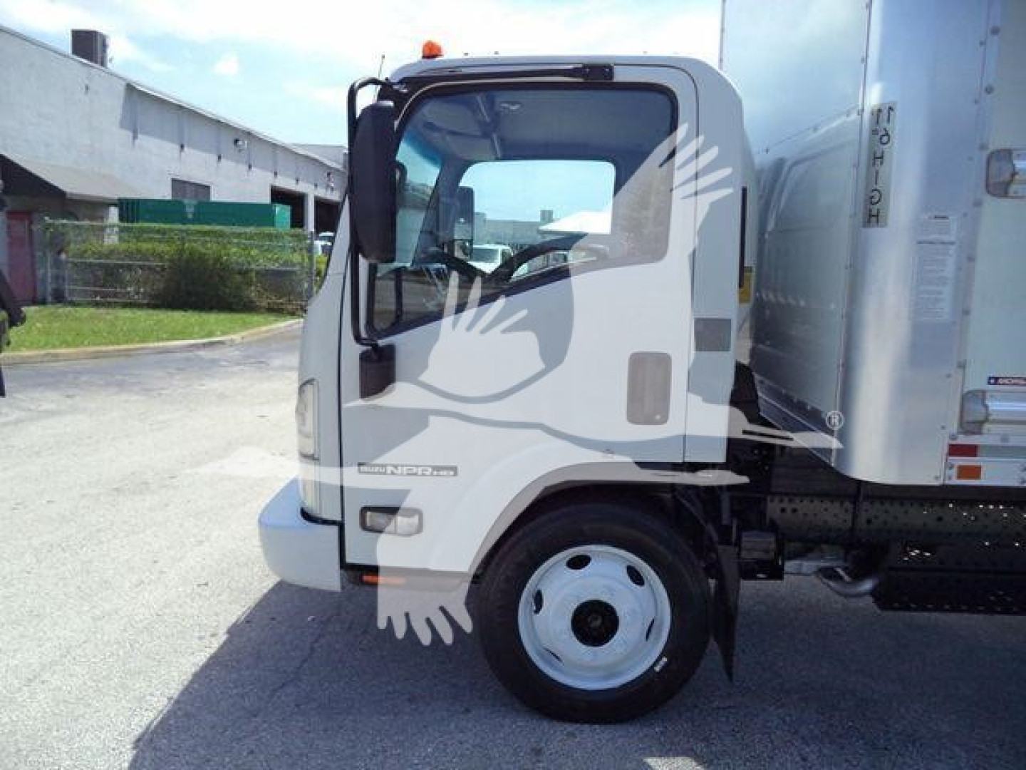 Isuzu NPR HD box truck cab side view with front wheel, door mirror, and cargo box visible