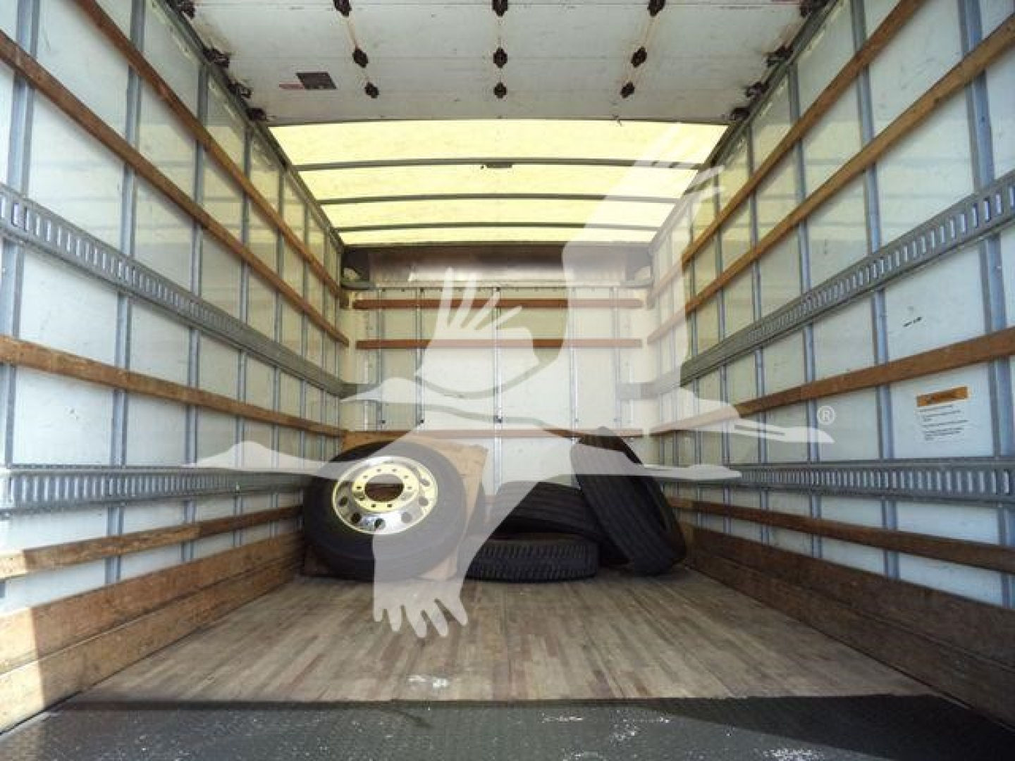 Isuzu NPR HD truck cargo area showing stacking tires inside empty box truck trailer.