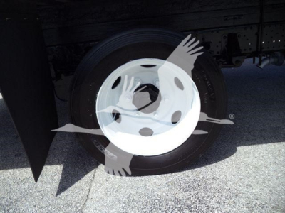 Truck wheel and tire under body of 2020 Isuzu NPR HD showing steel hub with tire