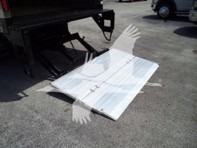 Isuzu NPR HD truck with a folded aluminum loading ramp on ground near rear of trailer, platform panel with handle hooks visible.