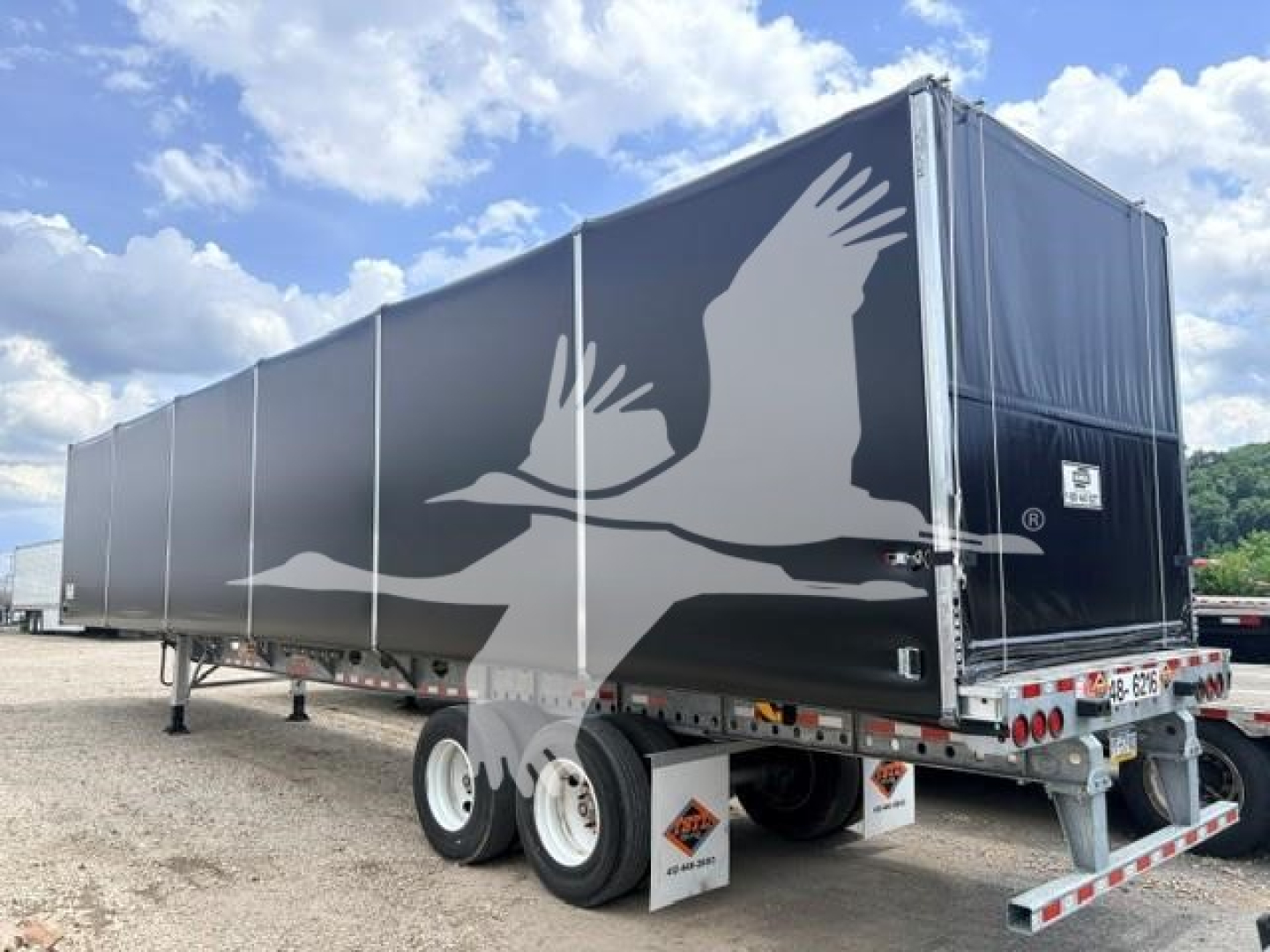 Curtainside trailer showing galvanized steel flat air slider with printed bird design and dual-axle wheels.