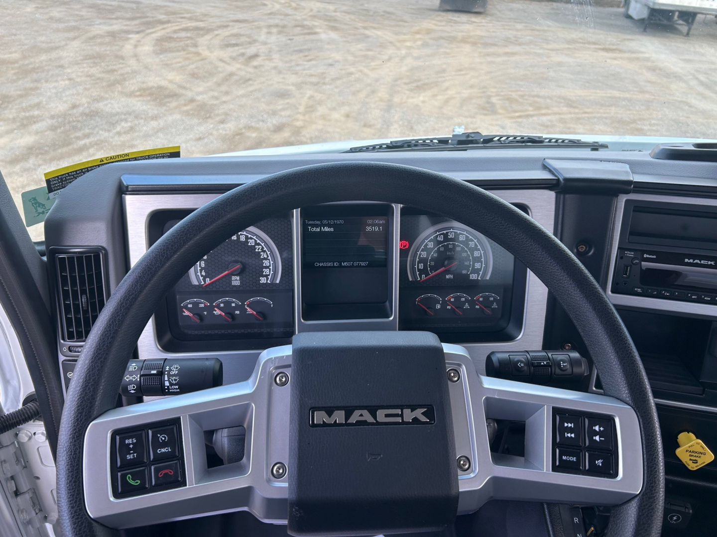 Dashboard and steering wheel of a Mack MD7 truck showing instrument cluster, steering wheel with IMACK badge, and center console with controls.