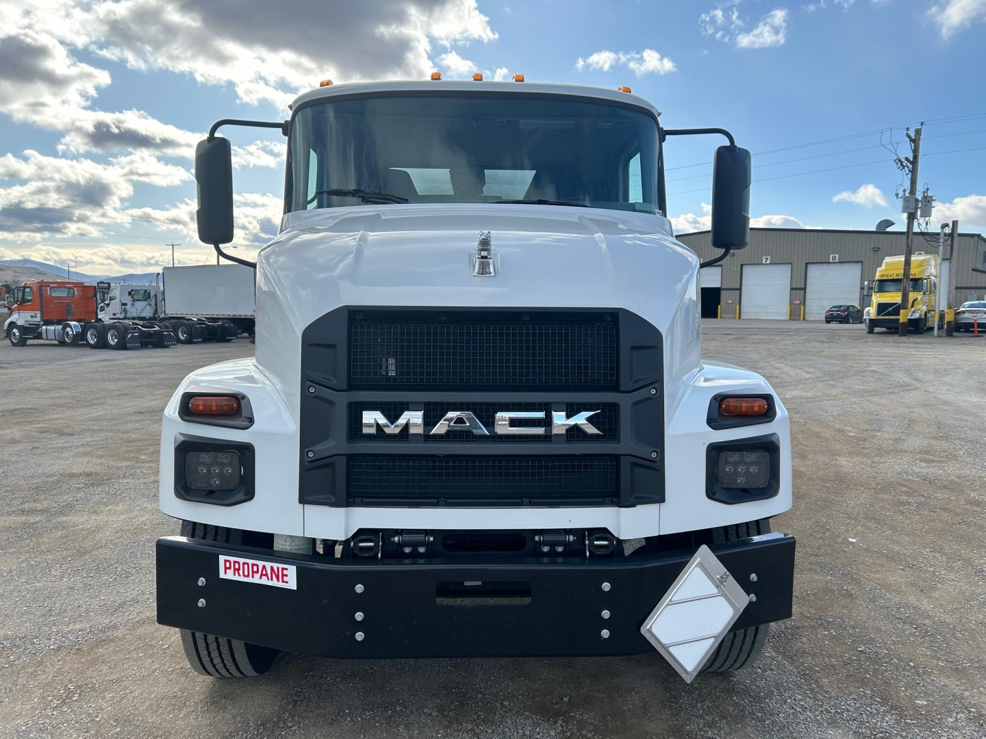 Front view of a white 2026 Mack MD7 truck showing large black front grille with MACK badge, rectangular headlights, and bumper with a Propane placard; VIN and stock not visible in text.