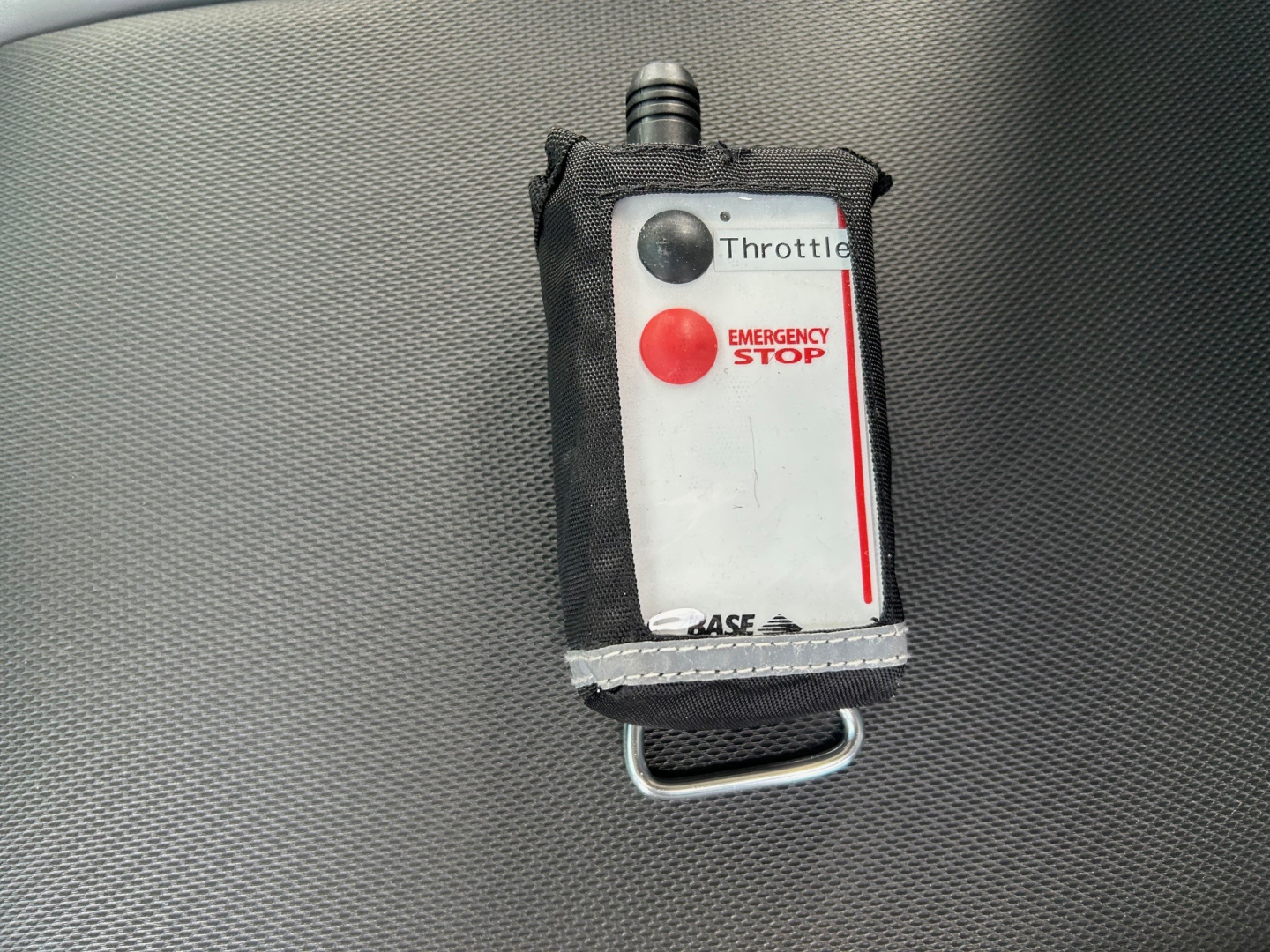 Control device labeled Throttle with emergency stop button and red/black dots.