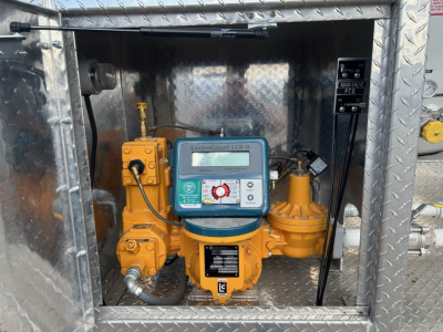 Mack MD7 engine bay view showing ElectroCounter LCR-11 flow meter and yellow hydraulic components inside diamond-plate metal enclosure.