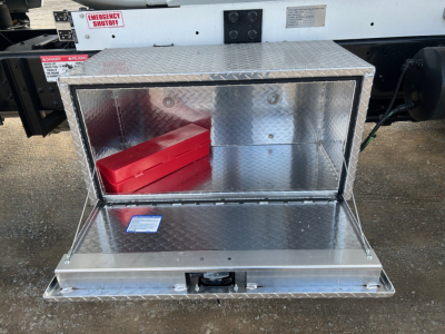 Aluminum toolbox on a Mack MD7 truck chassis, open hatch displaying a red toolbox inside.